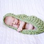 baby boy sleeps in green cacoon during newborn pictures in little rock arkansas