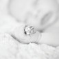 newborn boy holds his parents wedding rings during his newborn photography session with little rock photographer