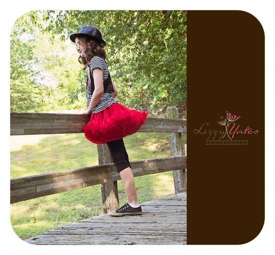 Girl in a red tutu looks thoughtfully over a bridge in North Little Rock
