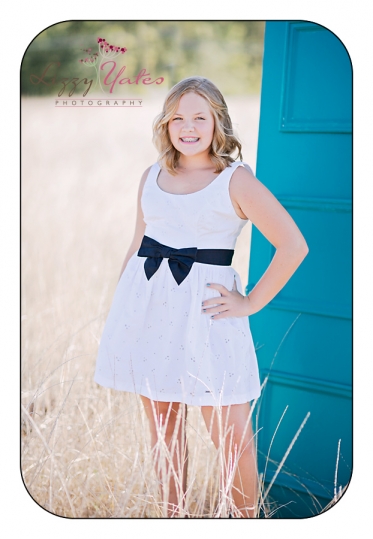 beautiful senior girl with terquoise door during custom pictures