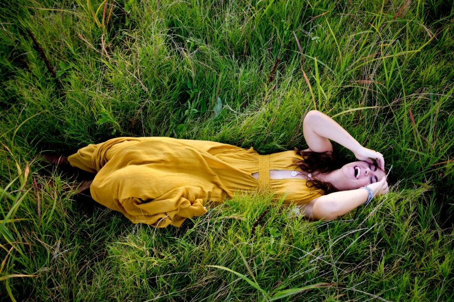 Senior girl lays in grass